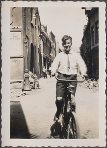 879286 Afbeelding van Nico Kool op z'n fiets in de Korte Viestraat in Wijk C te Utrecht. Zijn ouders hebben een ...